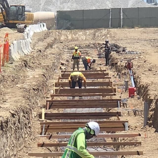 Formwork and rebar cages set in a continuous trench line for CMU wall footings.