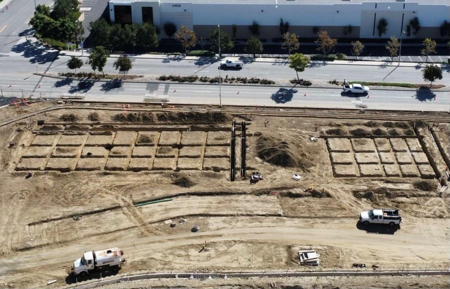 Aerial view of a site with spread footings excavated and laid out in a grid across the pad.